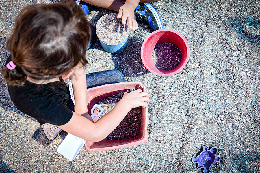 A little girl plays in the sandbox